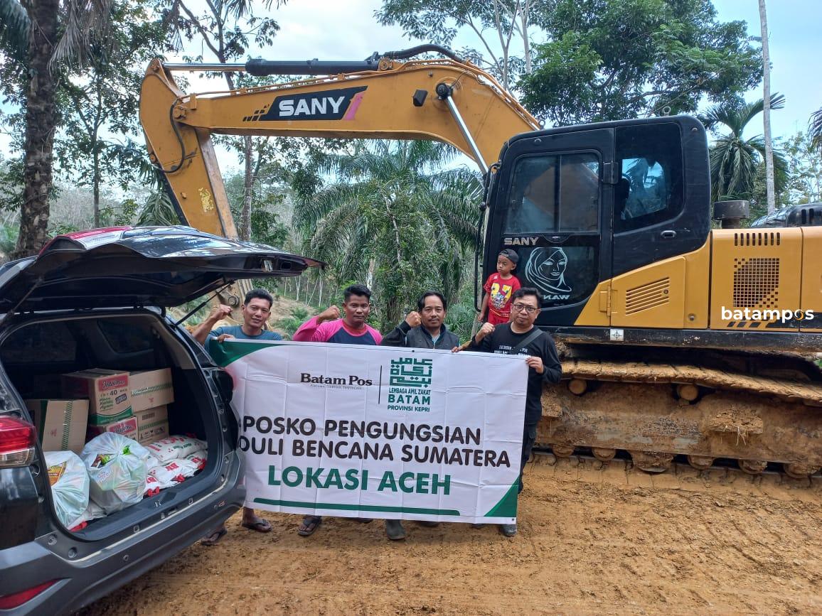 Tim LAZ BATAM–Batam Pos menurunkan bantuan kemanusiaan di titik jalan terputus akibat longsor menuju Kampung Alur Mentawak, Aceh Tamiang, Rabu (24/12/2025).