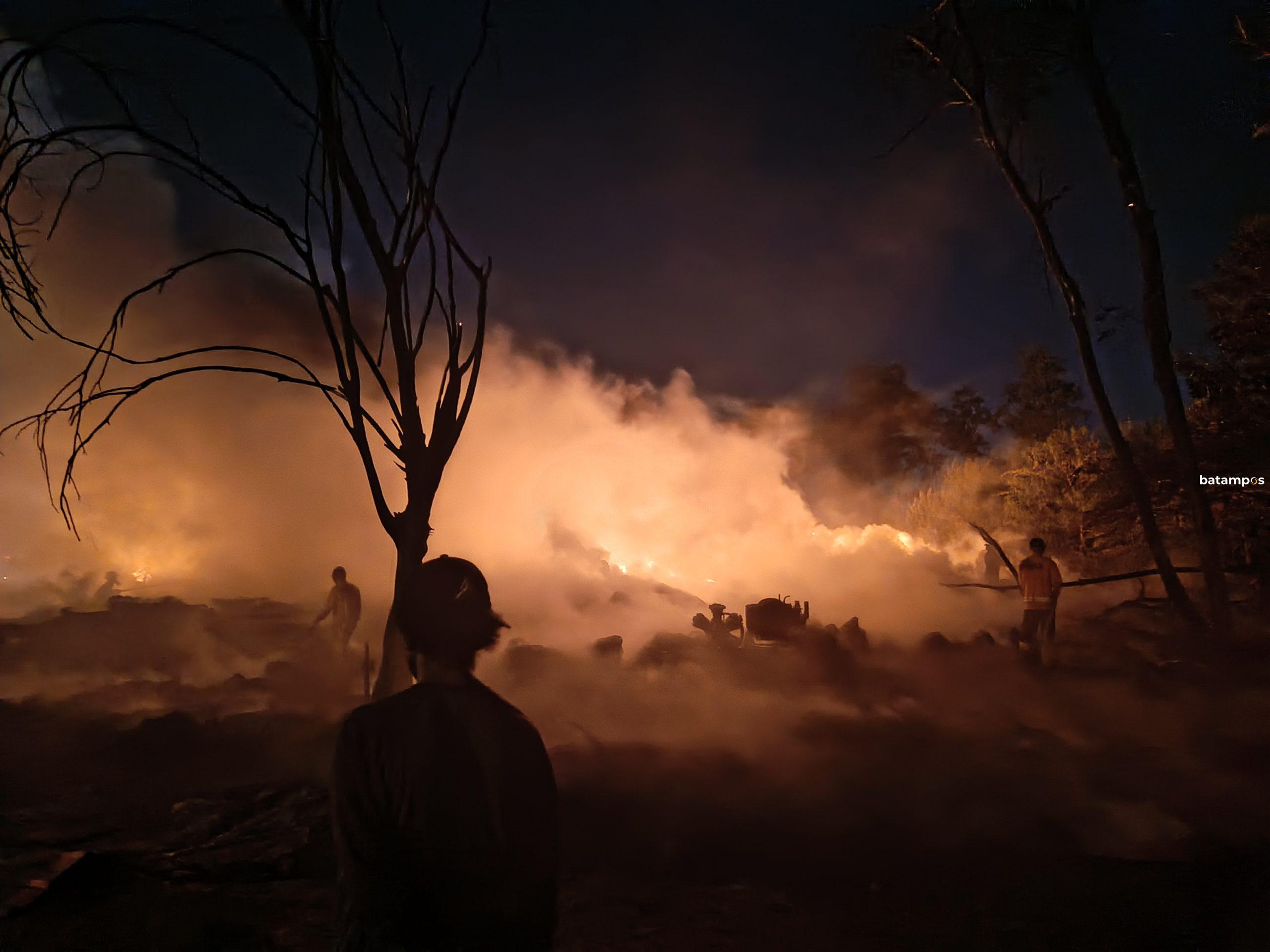Petugas pemadam kebakaran memadamkan kebakaran gudang ban bekas di Tanjunguncang, Batuaji, Batam, dengan asap hitam pekat membumbung ke udara.