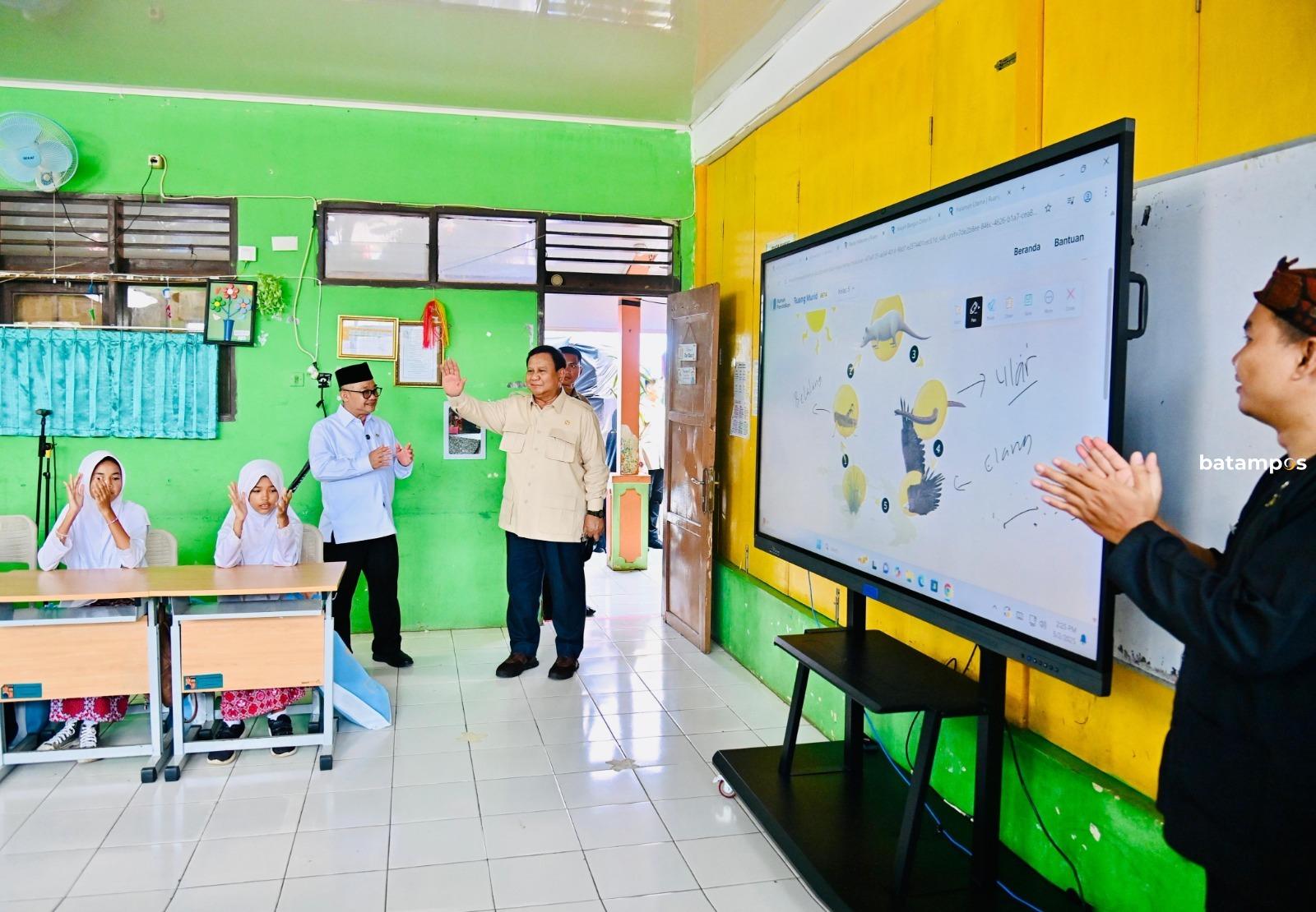Guru dan siswa menggunakan smart TV interaktif dalam kegiatan belajar mengajar di sekolah Kota Batam.