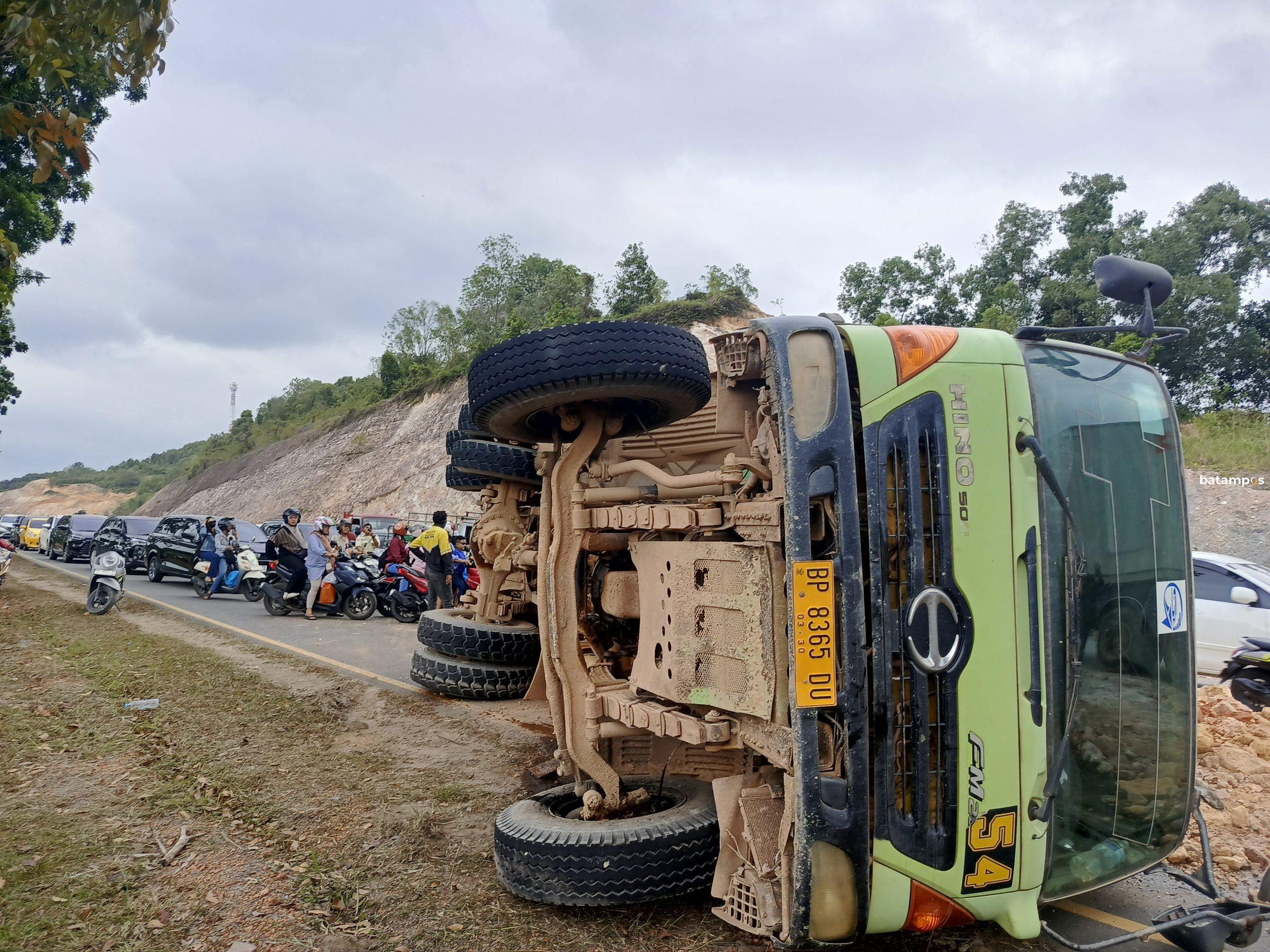Truk tanah terbalik di turunan Tiban Batam menutup sebagian badan jalan dan menyebabkan kemacetan lalu lintas.